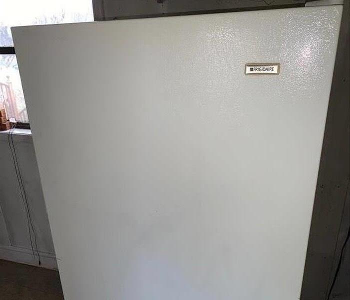 The refrigerator is spotless and completely white. 